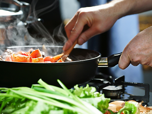 man cooking vegetables in a pan