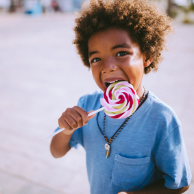Children eating colourful lollipops outdoors