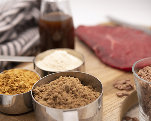 Beef ingredients in pans with flank steak in background