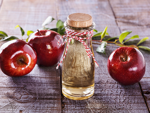 Apple cider vinegar bootle with apples background