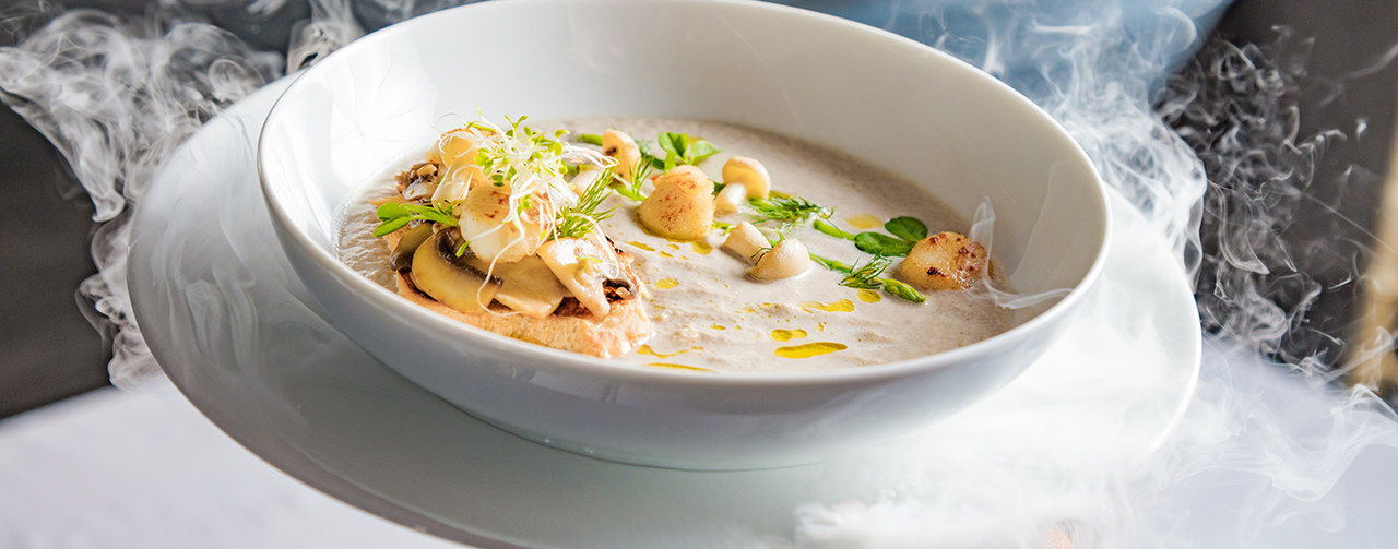 Cream mushroom soup with scallops, herbs, toast bread and dried ice mist