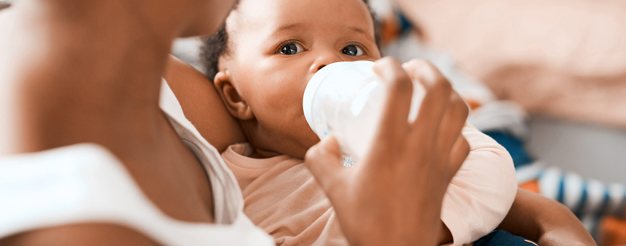 Mom feeding her baby with growing up milk