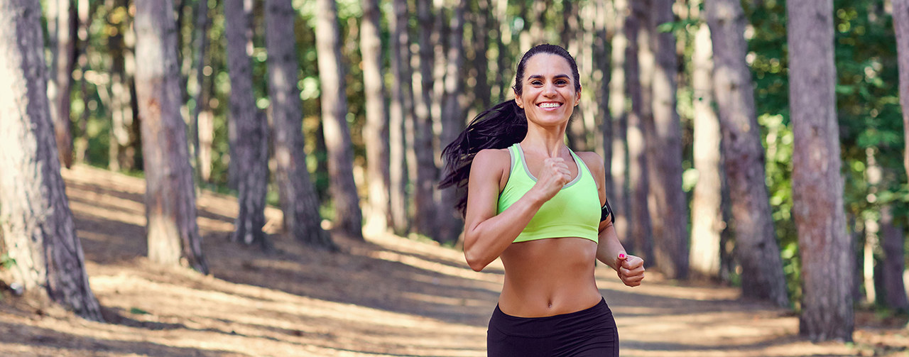 Sportive woman running in forest