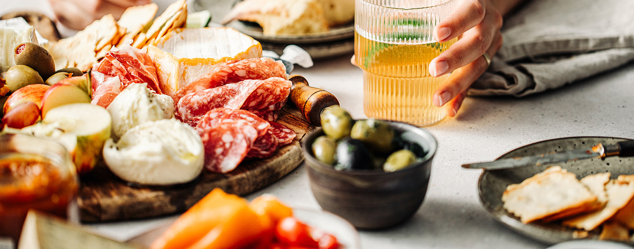 Woman eating processed meat and antipasti