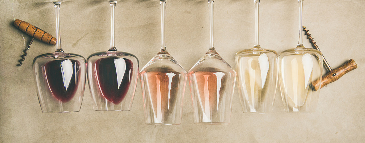 Top view of different wines in glasses in row and corkscrews