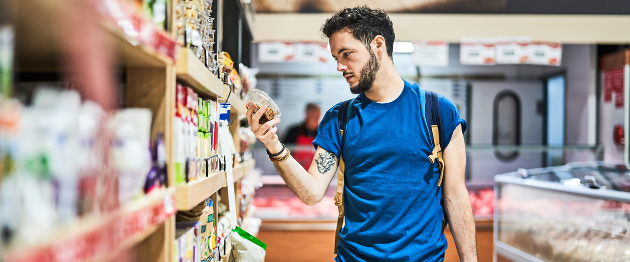 Man looking at packed food in supermarket