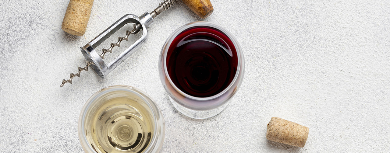 Top view of red and white wines glasses with corkscrew