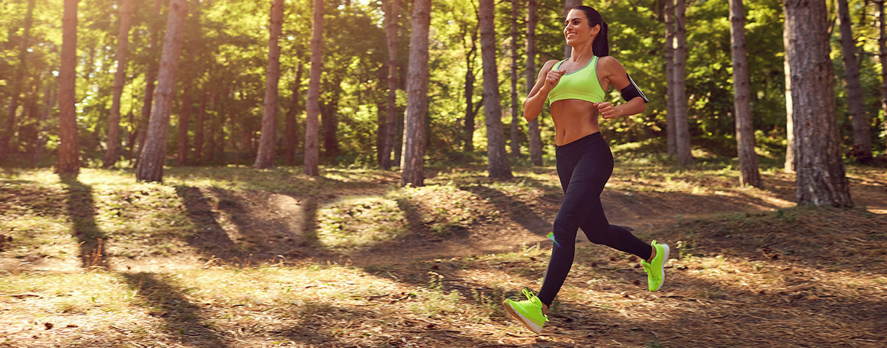 Sportive woman running in nature