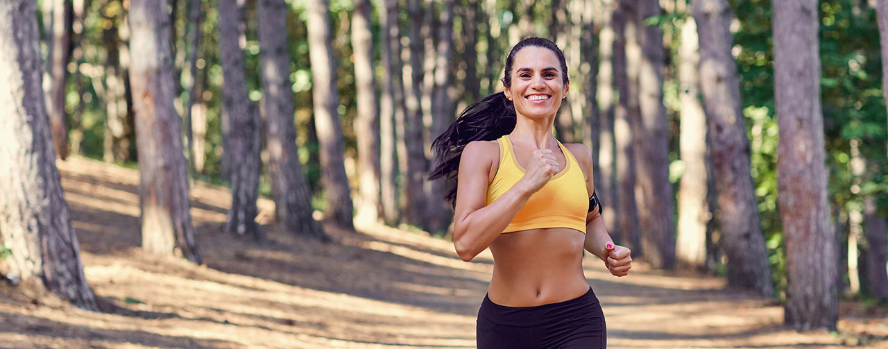 Sportive woman running in forest