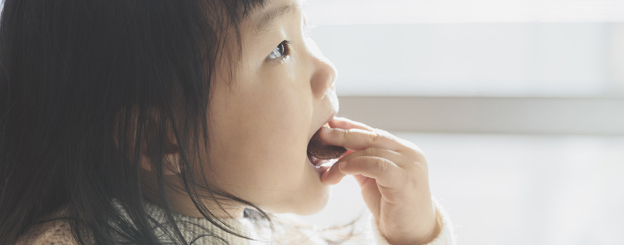 Baby girl eating toddler snack