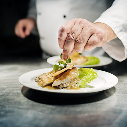 Chef adding herbs to his gourmet dish