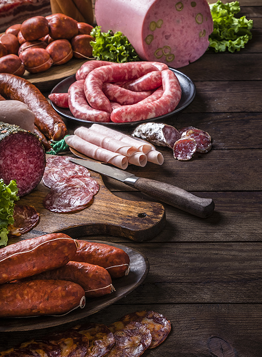 Assortement of processed and curet meat on wooden table