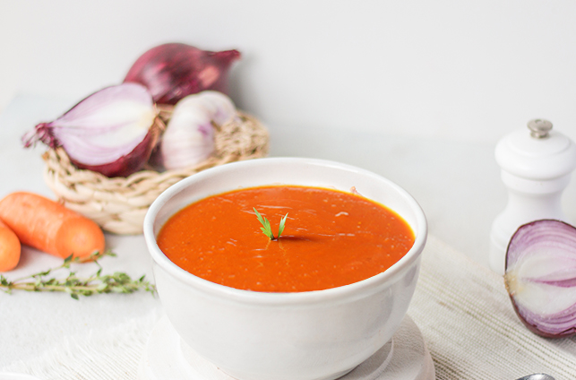 Puree soup tomato carrot and onion on white wooden table