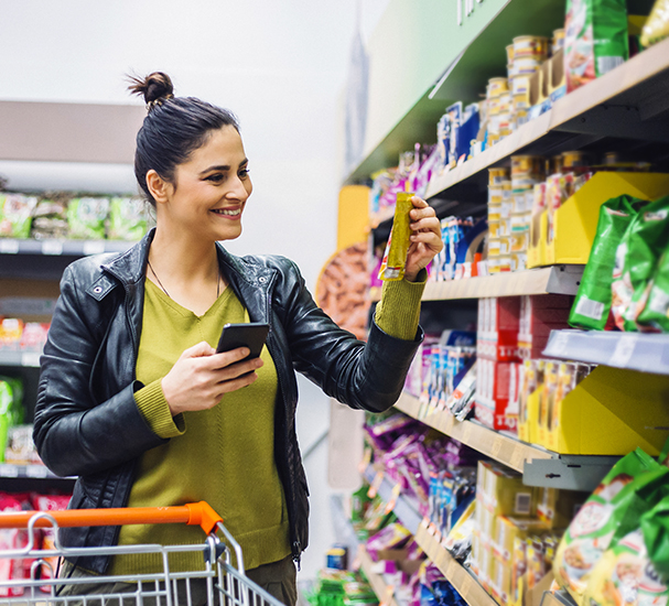 Happy woman buying snacks in a supermarket