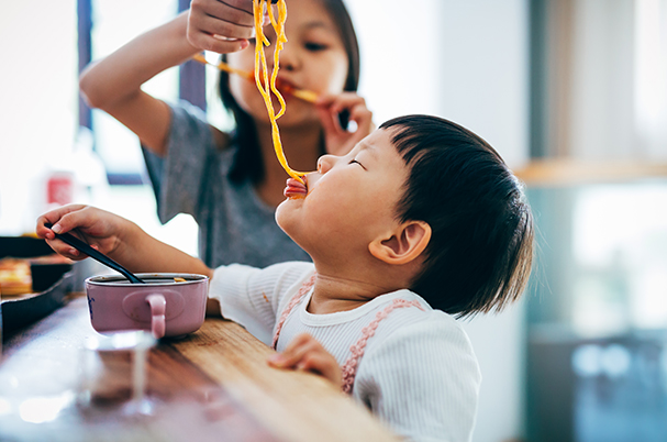 Asian baby boy eating noodles