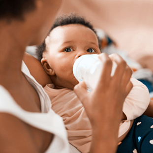 Mom feeding her baby with growing up milk