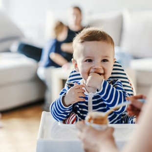 Mother feeding child with healthy food 