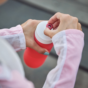 woman holding a sports gourd to quench thirst