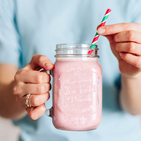 Woman holding a jar with pink milkshake