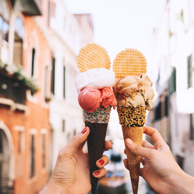 Hands holding trendy ice creams with biscuit, sprinkles