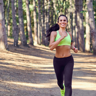 Sportive woman running in forest