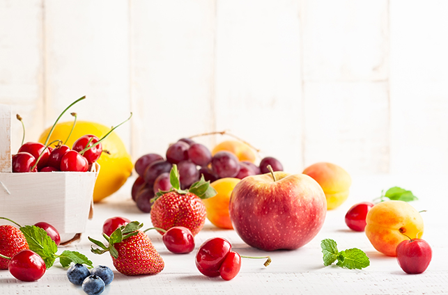Fruits on wooden table - Berries, apple, peach, pear acerola, grappe