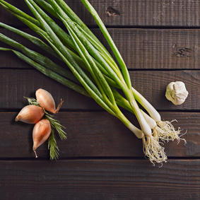 Top view of fresh leek, shallot and garlic on wooden table