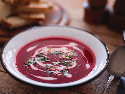 Trendy red beetroot soup on table