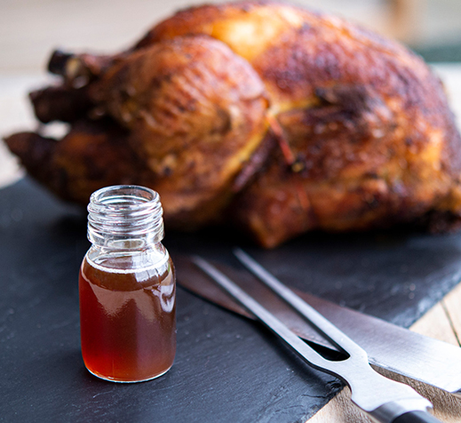 Chicken broth on slate with roasted chicken in the background