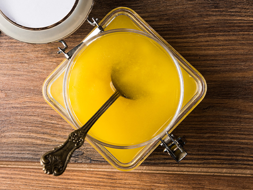 Top view of chicken fat in glass pot