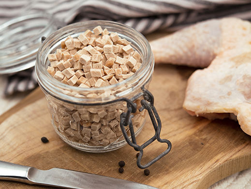 chicken pieces in glass pot with chicken thigh in background