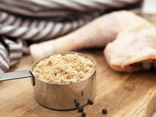 chicken powder in pan with chicken thigh in background