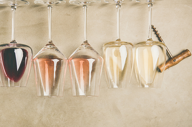 Top view of different wines in glasses in row and corkscrews