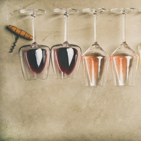 Top view of different wines in glasses in row and corkscrews