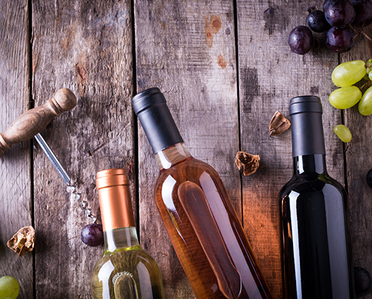 Top view of various wines bottles and grapes on wooden table 