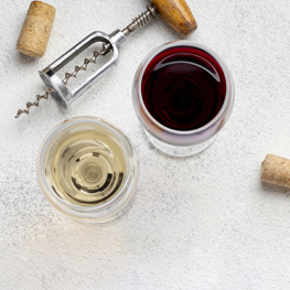 Top view of red and white wines glasses with corkscrew