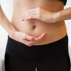 Woman holding hands on a belly with the drawing arrows