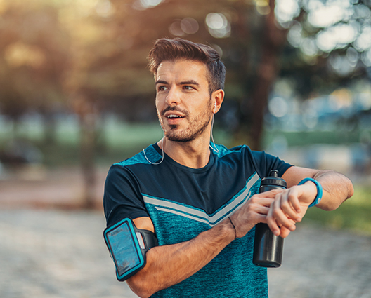 sportive man using a smart watch in the park
